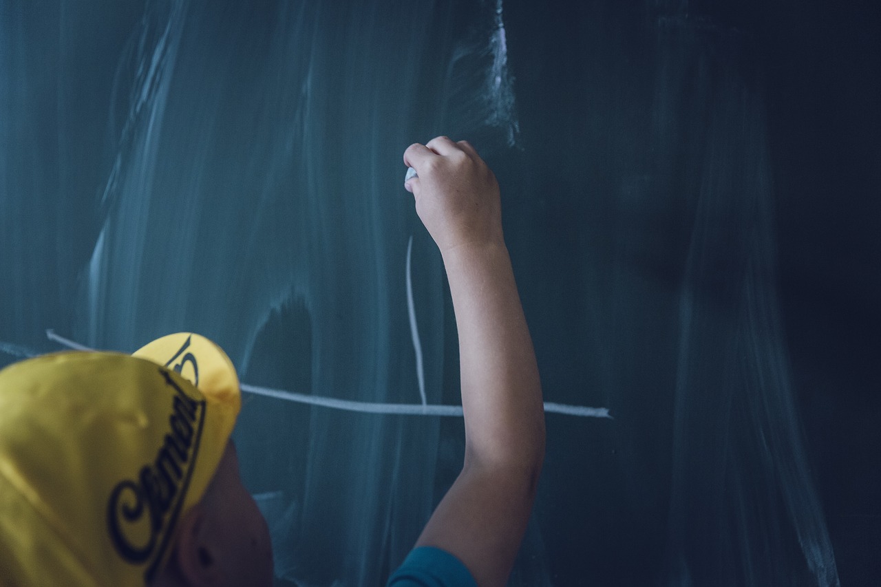child writing on a chalkboard