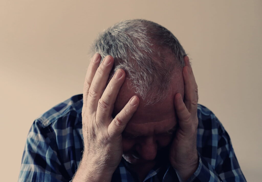 man holding his head after a traumatic brain injury