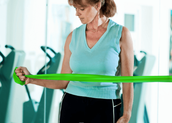 Woman performing rotator cuff exercises with a resistance band 